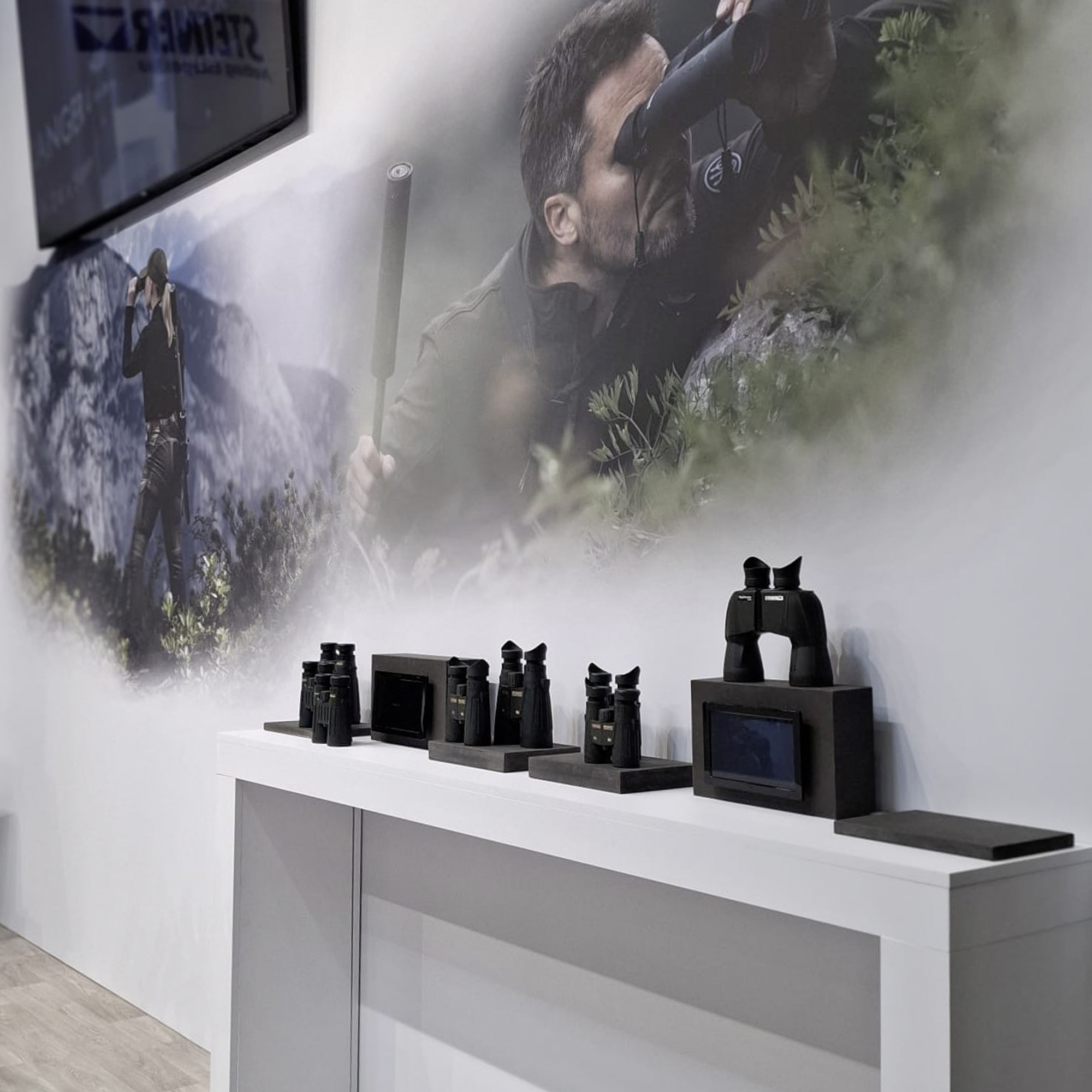 Ein Satz von Ferngläsern auf einem Tisch vor einer Wand.